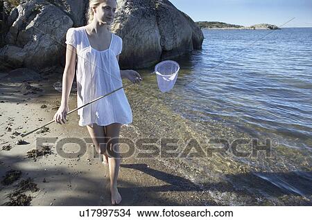 Picture - Young woman at beach.. Fotosearch