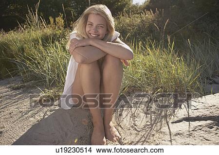 Picture - Young Woman Sitting at edge of beach.. Fotosearch