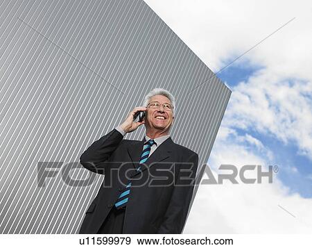 Stock Photo - Businessman by a silver wall.. Fotosearch