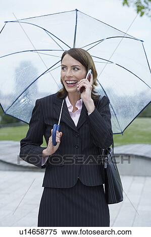 Stock Photography - Businesswoman with umbrella on the mobile.. Fotosearch