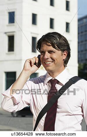 Stock Photo - Happy businessman on cell phone.. Fotosearch