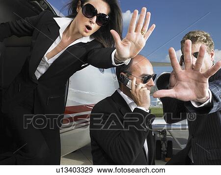 Stock Photo - Two bodyguards defending businessman while exiting jet.. Fotosearch