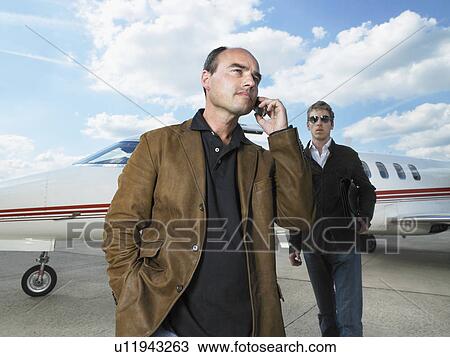 Two men beside private jet. View Large Photo Image Stock Image - Two men beside private jet.. Fotosearch