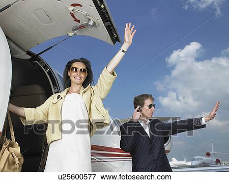Woman exiting plane waving with bodyguard. View Large Photo Image Stock Photo - Woman exiting plane waving with bodyguard.. Fotosearch