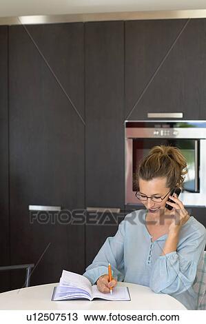 Woman in kitchen talking on phone. View Large Photo Image Stock Image - Woman in kitchen talking on phone.. Fotosearch