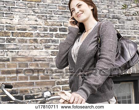 Woman with bike in front of brick wall View Large Photo Image Stock Image - Woman with bike in front of brick wall. Fotosearch