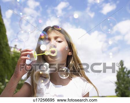 Stock Photography - Little girl blowing bubbles.. Fotosearch