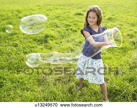 Little girl making soap bubbles. View Large Photo Image Stock Image - Little girl making soap bubbles.. Fotosearch