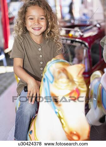 Stock Photo - Little girl on merry go round.. Fotosearch