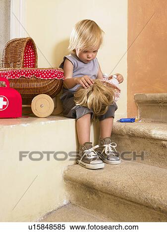 Stock Photography - Little girl playing with her doll.. Fotosearch