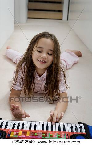 Stock Photo - Portrait of a girl with toy piano.. Fotosearch