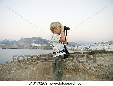 Stock Photo - Young boy using binoculars in Greece.. Fotosearch