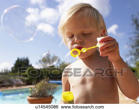 Young girl blowing bubbles outdoors by a pool. View Large Photo Image Stock Photograph - Young girl blowing bubbles outdoors by a pool.. Fotosearch