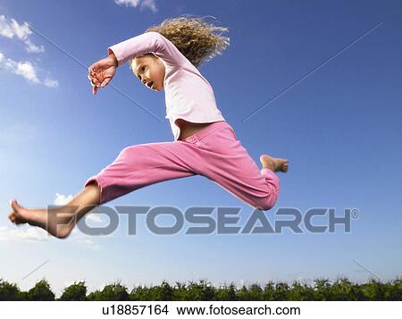 Picture - Young girl jumping in the air.. Fotosearch