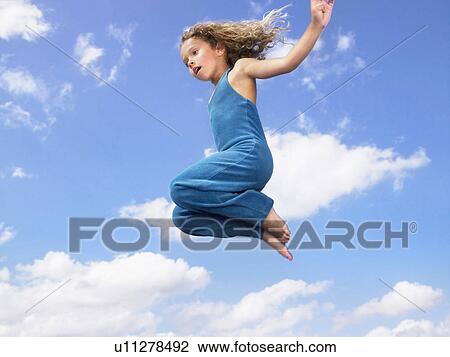 Stock Image - Young girl jumping in the air.. Fotosearch