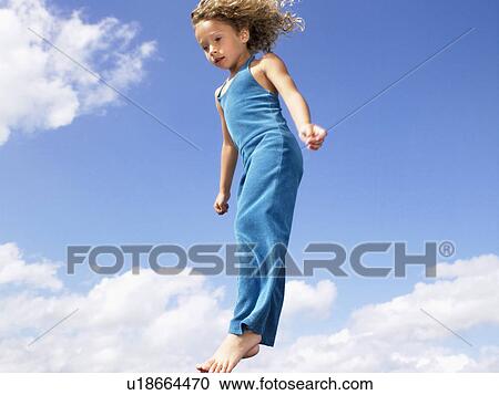 Stock Image - Young girl jumping in the air.. Fotosearch