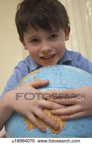 Boy carrying an earth globe View Large Photo Image Stock Image - Boy carrying an earth globe. Fotosearch