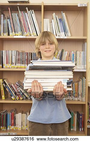Boy carrying books, smiling View Large Photo Image Stock Photograph - Boy carrying books, smiling. Fotosearch
