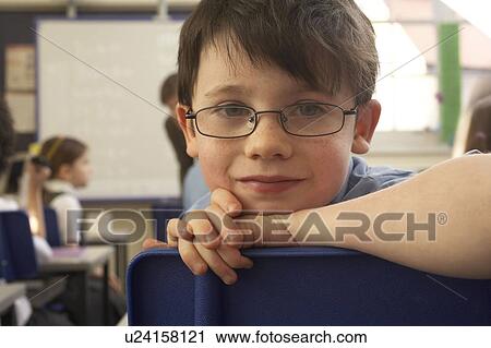 Boy looking at camera, in classroom View Large Photo Image Stock Image - Boy looking at camera, in classroom. Fotosearch
