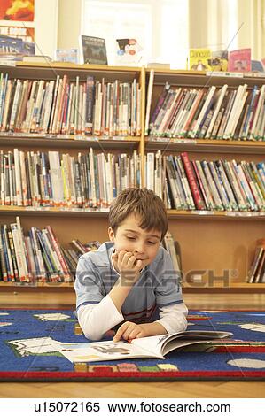 Boy reading a book on the floor View Large Photo Image Stock Photography - Boy reading a book on the floor. Fotosearch