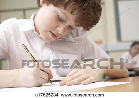 Boy writing in classroom View Large Photo Image Picture - Boy writing in classroom. Fotosearch