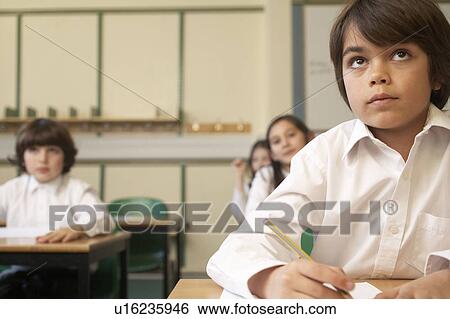 Stock Photograph - Children working in school. Fotosearch