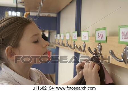 Girl hanging her coat in school View Large Photo Image Picture - Girl hanging her coat in school. Fotosearch
