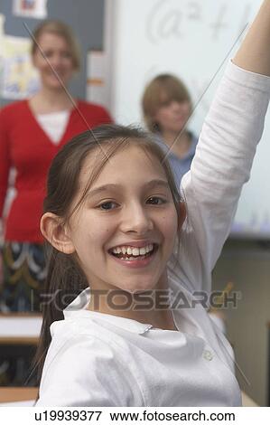 Stock Photo - Girl raising her hand in classroom. Fotosearch