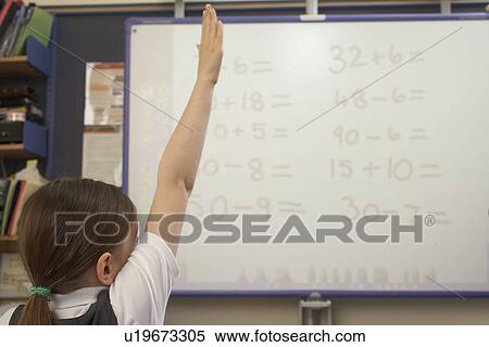 Stock Photography - Girl raising her hand in classroom. Fotosearch