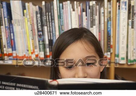 Stock Image - Girl reading a book, close up. Fotosearch