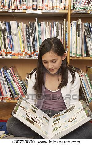 Girl reading a book on the floor View Large Photo Image Stock Image - Girl reading a book on the floor. Fotosearch