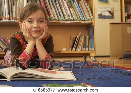 Stock Photo - Girl reading a book on the floor. Fotosearch