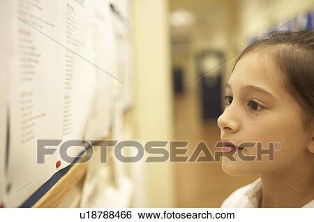 Stock Photograph - Girl reading message board. Fotosearch