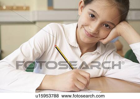 Stock Photo - Girl writing in classroom. Fotosearch