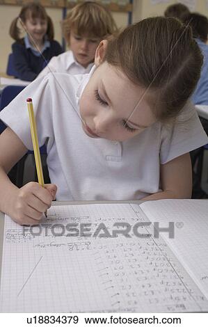 Stock Photo - Girl writing in classroom. Fotosearch