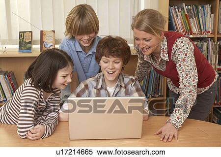 Group on computer, smiling View Large Photo Image Stock Photography - Group on computer, smiling. Fotosearch