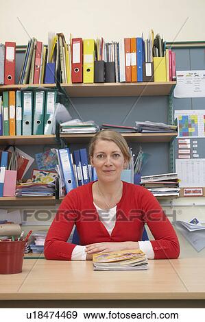 Stock Photo - Teacher sitting at her desk. Fotosearch