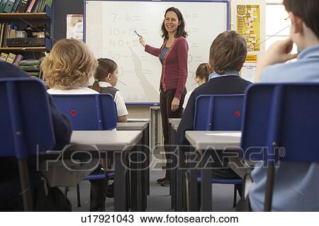 Stock Image - Teacher teaching in classroom. Fotosearch