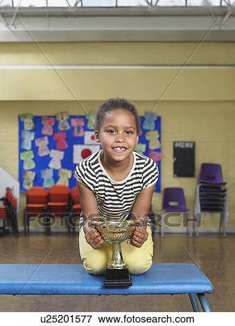 Young girl with trophy in school hall View Large Photo Image Stock Photo - Young girl with trophy in school hall. Fotosearch