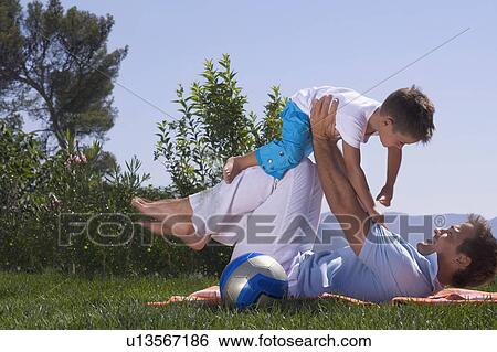 Stock Photograph - Father and son playing on a picnic rug.. Fotosearch