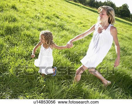 Stock Photograph - Little girl and young woman walking.. Fotosearch