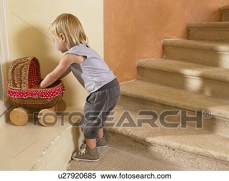 Stock Photography - Little girl playing with her stroller.. Fotosearch