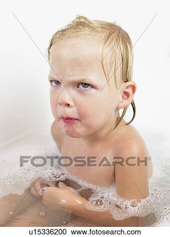 Stock Image - Little girl taking a bath making a face.. Fotosearch