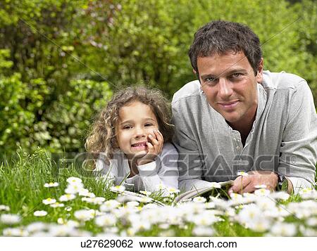 Man and young girl lying in the grass smiling. View Large Photo Image Stock Image - Man and young girl lying in the grass smiling.. Fotosearch