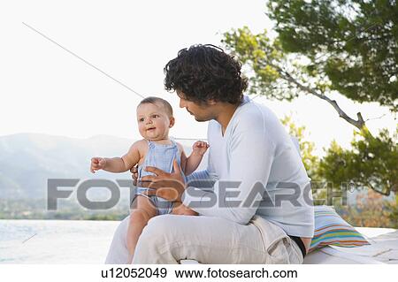 Stock Photo - Man holding baby outside.. Fotosearch