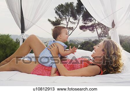 Woman and baby on bed outdoors. View Large Photo Image Stock Image - Woman and baby on bed outdoors.. Fotosearch