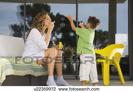Woman and boy blowing bubbles. View Large Photo Image Stock Image - Woman and boy blowing bubbles.. Fotosearch