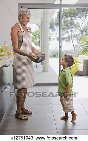 Woman showing baking dish to boy. View Large Photo Image Stock Image - Woman showing baking dish to boy.. Fotosearch