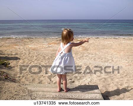 Young boy standing and pointing on a wooden path at the beach. View Large Photo Image Stock Photography - Young boy standing and pointing on a wooden path at the beach.. Fotosearch