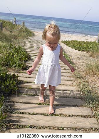 Young boy walking on a wooden path at the beach. View Large Photo Image Stock Image - Young boy walking on a wooden path at the beach.. Fotosearch